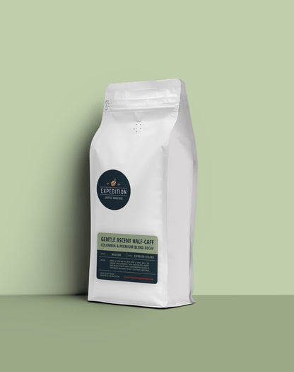 Gentle Ascent half-caff coffee beans in a white coffee bag with a label on a light green background