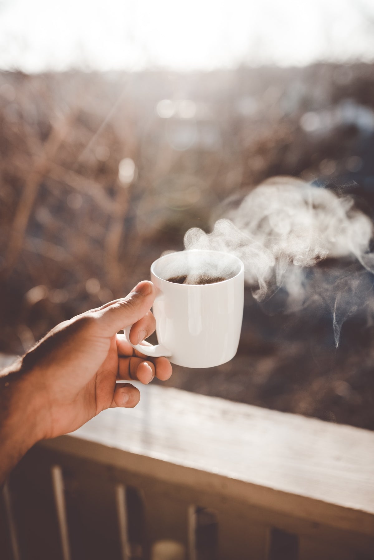 Nova Scotia coffee roasters with a man holding hot cup of coffee on his patio