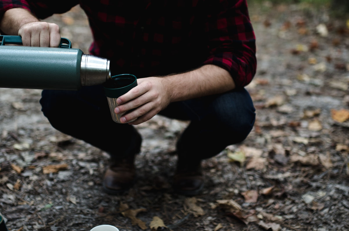 man pouring camp coffee from a thermos